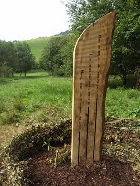 Hazel spiral around oak marker post with text by James Crowden